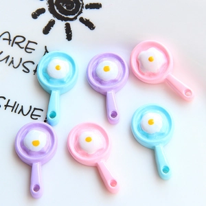 Macro shot of colorful resin miniature frying pans with fried eggs for DIY accessories