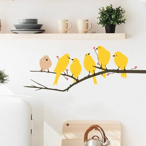 Detail of creative bird on branch wall sticker on a white kitchen wall backdrop