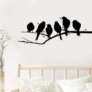 Detail of bird branch wall stickers in a modern bedroom setting with black silhouette