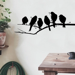 Detail of bird silhouettes on branches wall stickers in a cozy modern living room setting