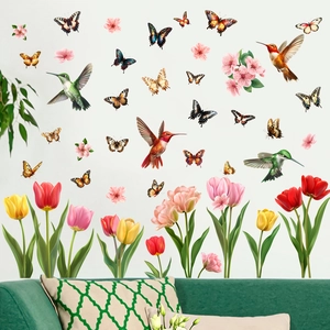 Detail of hummingbird and colorful tulip wall stickers on white wall above a sofa