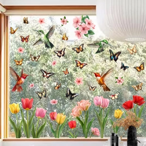 Detailed view of colorful hummingbird and butterfly static stickers on window glass