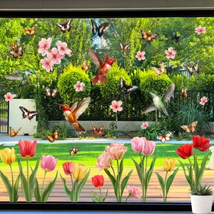 Detailed view of hummingbird and tulip window static cling stickers on glass surface