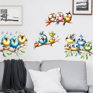 Detailed view of colorful bird wall stickers on branches above a gray sofa in a living room