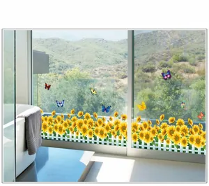 Détail de stickers muraux clôture de tournesols avec papillons colorés sur une vitre