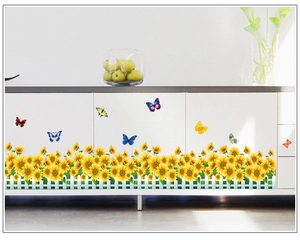 Détail de stickers tournesols et clôture blanche sur le bas d'un meuble blanc