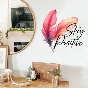 Detail showing decorative feather wall decals with Stay Positive quote in living room