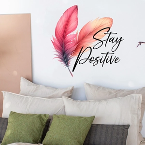 Detail showing Stay Positive phrase and gradient feather wall stickers in a cozy bedroom