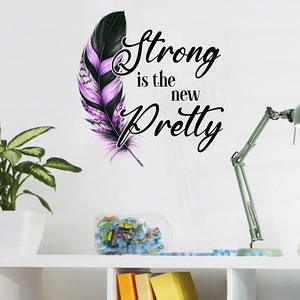 Detailed view of feather wall sticker with 'Strong is the new Pretty' text decor