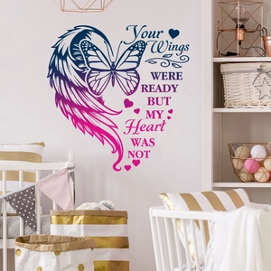 Detail view of butterfly and heart wall decal with emotional quote in nursery room