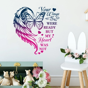 Close-up of butterfly and feather wall decal with sentimental quote on a white wall
