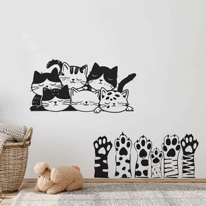 Detail of cute black and white cartoon cat head and paw wall decals on a white wall