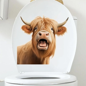 Gros plan détaillé d'un autocollant de vache écossaise sur un couvercle de toilette blanc