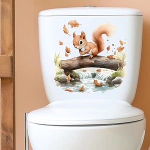 Waterproof squirrel wall decal with autumn leaves applied to a ceramic toilet tank