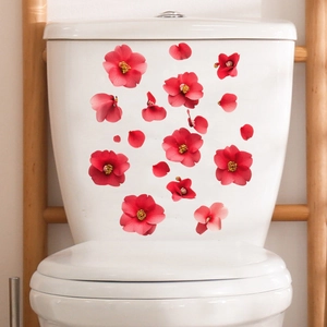 Détail de stickers muraux fleurs rouges sur la surface d'un réservoir de toilette blanc