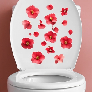 Détail des stickers fleurs de camélia rouge appliqués sur un couvercle de toilette blanc
