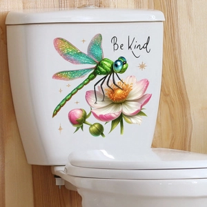 Detail of dragonfly and flower wall sticker with Be Kind text on a white surface