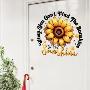 Detail of sunflower wall sticker with motivational text on a white wooden door