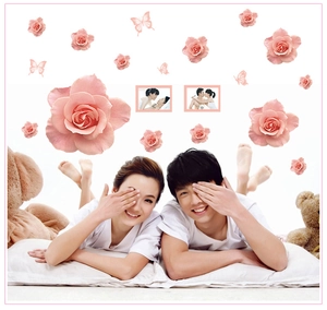 Detail view of pink rose wall stickers with butterfly accents in a romantic bedroom setting