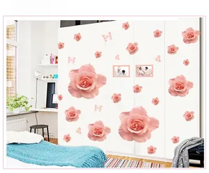 Detail view of pink rose and butterfly wall stickers on a minimalist white wardrobe surface
