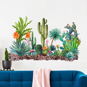 Watercolor cactus wall stickers shown above a blue velvet sofa in a living room