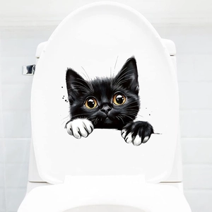 Macro detail of 3D peeping black cat sticker with yellow eyes on white toilet cover