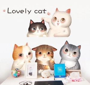 Detail of five cute cartoon cat stickers applied to a white wall in a study room setting