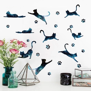 Close-up of starry blue cat silhouette wall stickers with paw prints on a white wall