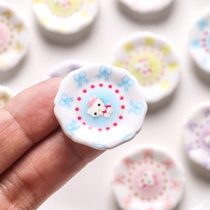 Miniature wave-edged ceramic dollhouse plates with cartoon cat face and polka dots