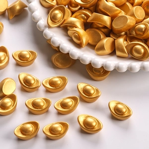 Macro detail of miniature golden sycee ornaments with matte texture on a white plate