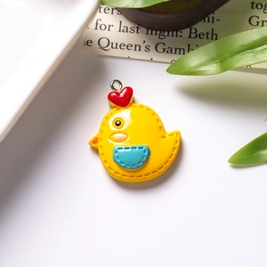 Detail view of mini resin yellow chick pendant with red heart and silver metal loop