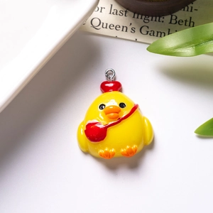 Detailed close-up of a resin cartoon chicken pendant with a red heart and silver ring