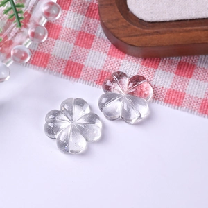 Detailansicht von zwei transparenten DIY-Schmuckperlen in Blumenform mit Glitzer