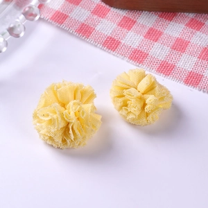 Détail de deux pompons jaunes de 2,5 cm en tulle élastique pour accessoires cheveux