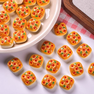 Macro shot of miniature resin pizza bread charms for DIY dollhouse crafts and decor