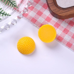 Detailed view of yellow resin soccer ball cabochons for DIY jewelry and crafts