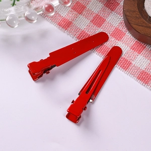 Detail of red metal alligator hair clips with a smooth matte finish for DIY hair accessories