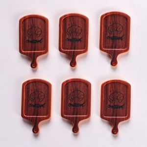 Detailed view of six miniature resin bread boards with croissant prints for dollhouses
