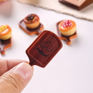 Miniature dollhouse food tray set with resin pastries and small wooden serving board