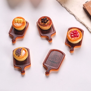 Detailed macro of 5 miniature resin dollhouse dessert trays with fruit toppings