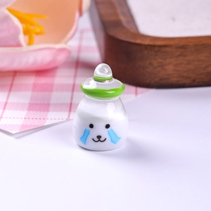 Macro view of a miniature resin milk bottle charm with cute expression and green neck ring
