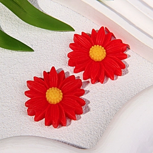 Vista macro di due ciondoli a margherita in resina rossa per accessori per gioielli fai da te