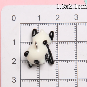 Detailed view of resin panda charm measuring 1.3x2.1cm on a white scale ruler