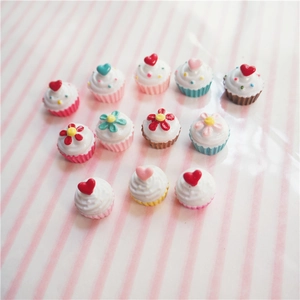 Macro view of miniature resin cupcakes with heart and flower decorations for DIY crafts