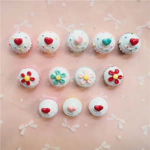 Flat lay of colorful resin heart cupcake charms for DIY phone case decoration