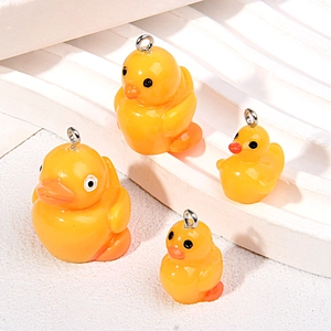 Macro shot of 3D resin yellow duck pendants with silver metal loops for DIY crafts