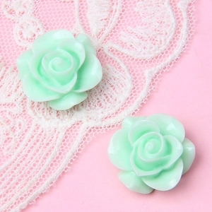 Makroansicht von mintgrünen Harz-Rosen-Anhängern für DIY-Schmuck und Haarspangen