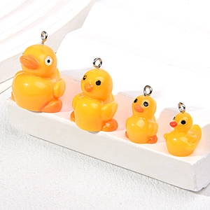 Set of four yellow resin duck pendants in varying sizes with silver metal rings