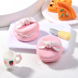Makroaufnahme von Mini-Herz-Macarons mit Tablett und Erdbeer-Tassen-Zubehör-Set