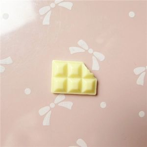 Creamy yellow chocolate shape resin DIY accessory on sweet pink background with bow